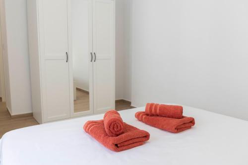 dwa ręczniki na białym łóżku z lustrem w obiekcie Sol y Mar Boutique Apartments w Alicante