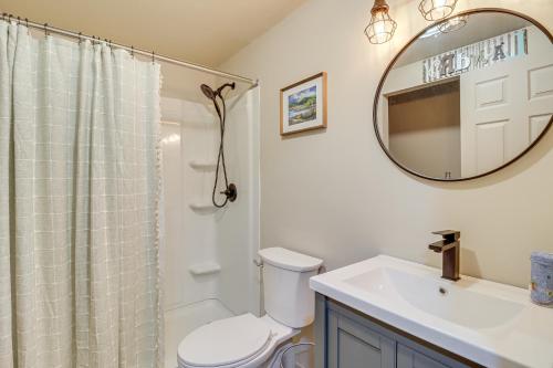 y baño con aseo, lavabo y espejo. en Quaint Jim Thorpe Cabin Retreat, Walk to Beach!, en Jim Thorpe