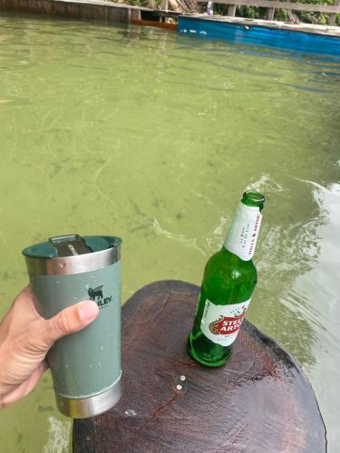 a person holding a cup and a bottle of beer at Camping rustico recanto do combatente in Manaus