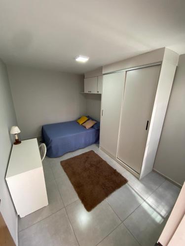 um pequeno quarto com uma cama azul e armários em Casa Ceci SUÍTES/QUARTOS em São Paulo