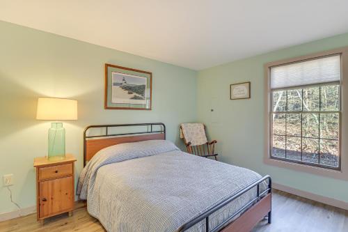 1 dormitorio con cama, ventana y silla en Quaint Jim Thorpe Cabin Retreat, Walk to Beach!, en Jim Thorpe