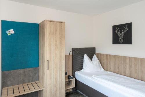 ein Schlafzimmer mit einem Bett und einem Schrank mit einem Bett sidx sidx in der Unterkunft Tespo Hotel und Sportpark in Kaarst