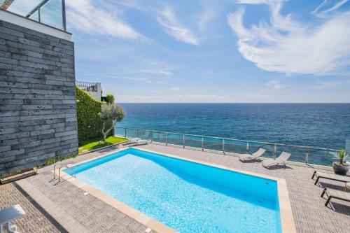 a swimming pool with the ocean in the background at Beach House - By WeHost in Santa Cruz