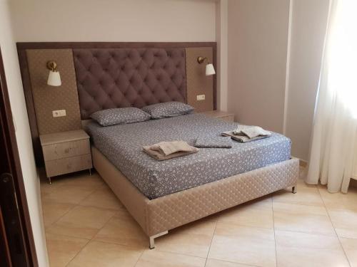 a bedroom with a large bed with a large headboard at Kriopigi Apartments 2 in Kriopigi