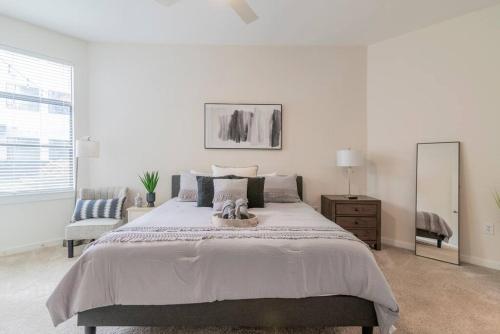 1 dormitorio blanco con 1 cama grande y espejo en Cozy Apartment with WiFi en Charlotte