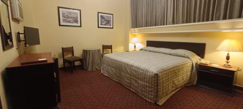 a hotel room with a bed and a television at Hotel Montecarlo in Tampico