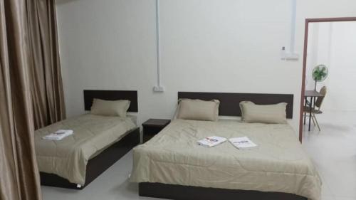 a bedroom with two beds and a mirror at Happy homestay in Teluk Intan