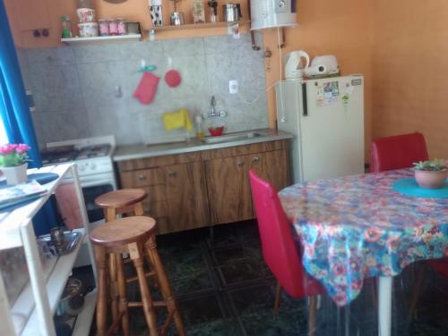 uma cozinha com uma mesa e um frigorífico em Casa Colibri em Merlo