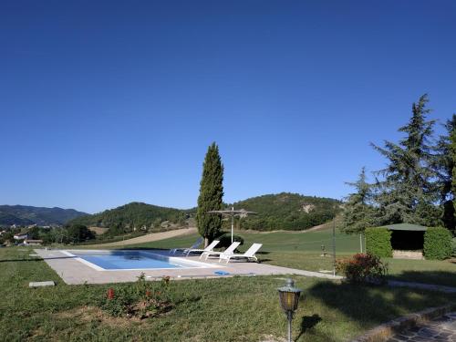 una piscina con 2 tumbonas en un patio en Villa Paola Holidays en SantʼAngelo in Vado