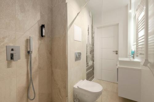 biała łazienka z toaletą i umywalką w obiekcie BKS Locum Parking Dostęp Na Kod blisko Galeria Łódzka, Piotrkowska, Jednorożec w Łodzi