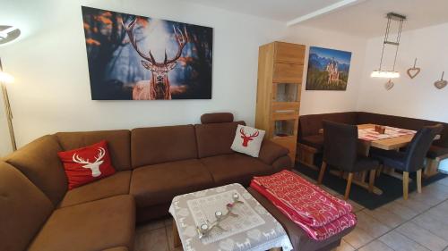 sala de estar con sofá marrón y mesa en Lechbruck am See Feriendorf Hochbergle Haus 131, en Lechbruck