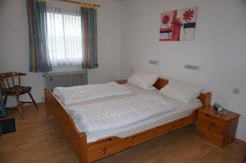 1 dormitorio con 1 cama, 1 silla y 1 ventana en Lechbruck am See Feriendorf Hochbergle Haus 139, en Lechbruck