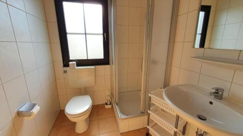 y baño con aseo, lavabo y ducha. en Lechbruck am See Feriendorf Hochbergle Haus 139, en Lechbruck