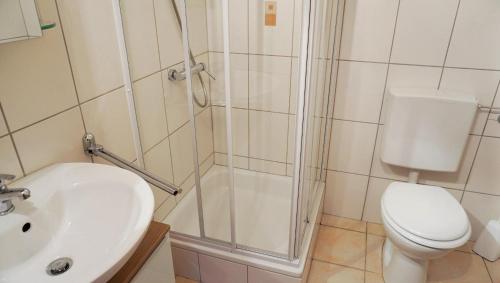 une salle de bains avec douche, toilettes et lavabo dans l'établissement Lechbruck am See Feriendorf Hochbergle Haus 140, à Lechbruck am See
