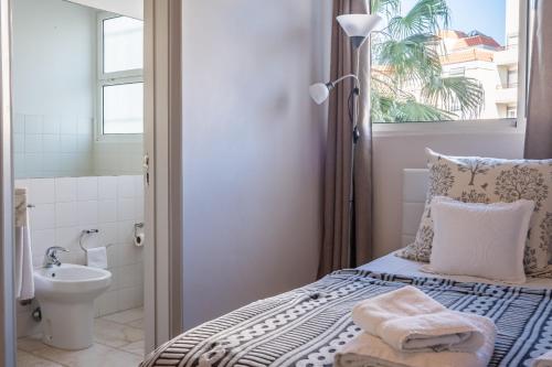 a bedroom with a bed and a bathroom with a sink at Apartamento Jasmineiro in Funchal