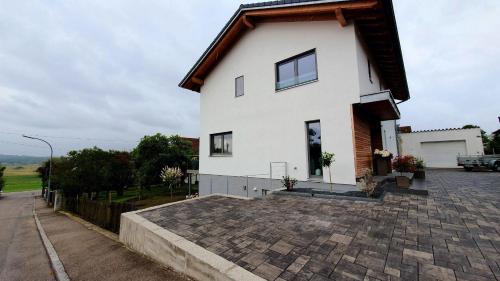 a white house on a brick driveway at Bei München Ferienwohnung am Ampermoos in Kottgeisering "am Ampermoos" in Kottgeisering