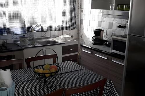 uma cozinha com uma mesa com uma taça de fruta em Apartamentos em SC em Itajaí