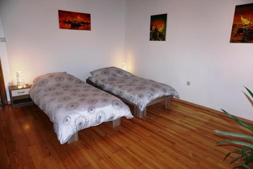 two beds in a room with wooden floors at Bei München Ferienwohnung in Dachau "Burgmair" in Dachau