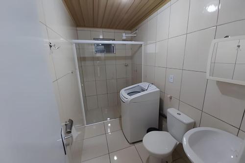 uma casa de banho branca com um WC e um chuveiro em Apartamentos em SC em Itajaí