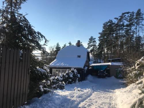 a house with a snow covered roof in a yard at Lesanka in Všelibice