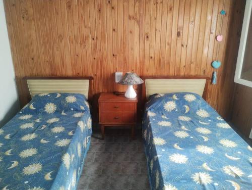 two beds sitting next to each other in a bedroom at Encantadora Casa con parque in La Falda