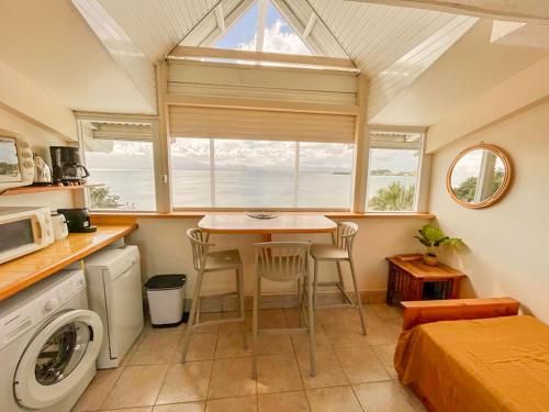 een kleine keuken met een tafel en een raam bij Appartement Les Yuccas, vue sur la mer et les montagnes in Le Gosier