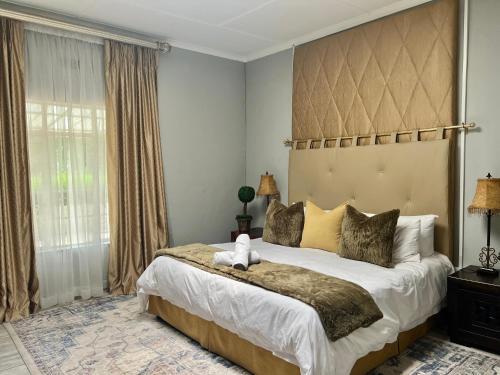 a bedroom with a large bed with a large headboard at Silken Trap Guest House NO LOADSHEDDING in Johannesburg