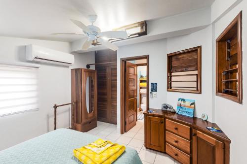 1 dormitorio con 1 cama y ventilador de techo en Condo 26 at Caribe Island Gold Standard Certified, en San Pedro