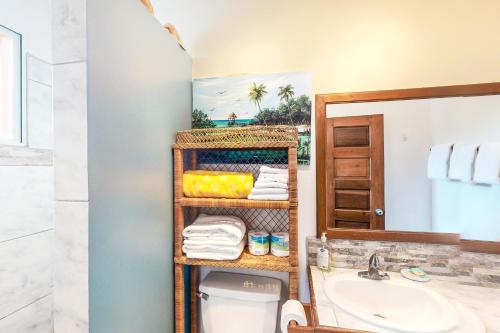 y baño con lavabo, aseo y espejo. en Condo 26 at Caribe Island Gold Standard Certified, en San Pedro