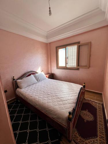 1 dormitorio con cama y ventana en Julie's AIRPORT Apartment en Marrakech