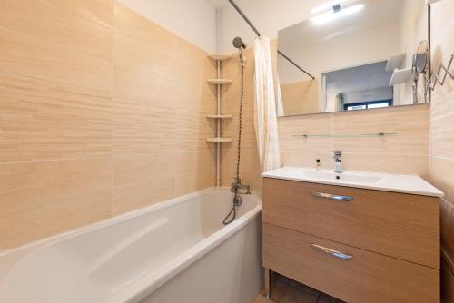 une salle de bain avec une baignoire et un lavabo et une baignoire dans l'établissement T2 dans résidence, Terrasse privée et Parking, à Toulouse
