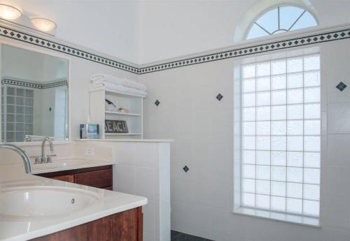 baño blanco con lavabo y ventana en Oceanfront Perfection - 5 Bedroom Private Paradise, en Ponte Vedra Beach