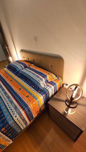 een bed met een kleurrijk dekbed en een houten tafel bij Olive Garden's Paradise Villa in Skarinou