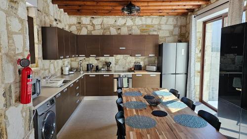 a kitchen with a table with chairs and a refrigerator at Olive Garden's Paradise Villa in Skarinou