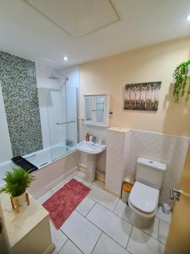 a bathroom with a toilet and a sink and a shower at 3 Bed House Etihad in Manchester