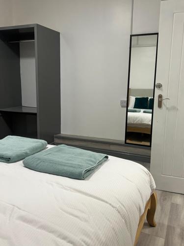 a bedroom with two beds and a mirror at En-suite room in Swansea