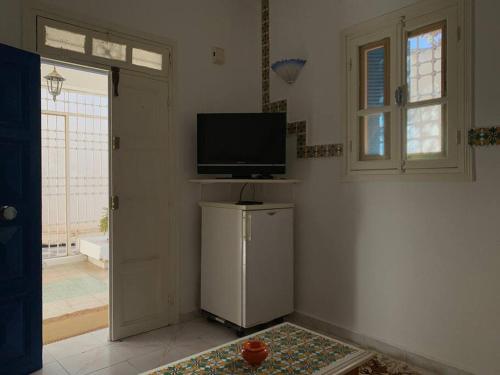 a living room with a television and a small refrigerator at Studio Bellina in Mezraya