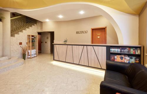 a lobby with a reception counter in a building at Sándor Hotel in Pécs