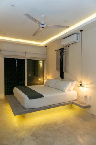 a bedroom with a large white bed with a window at Kanté Hotel - Downtown Tulum in Tulum