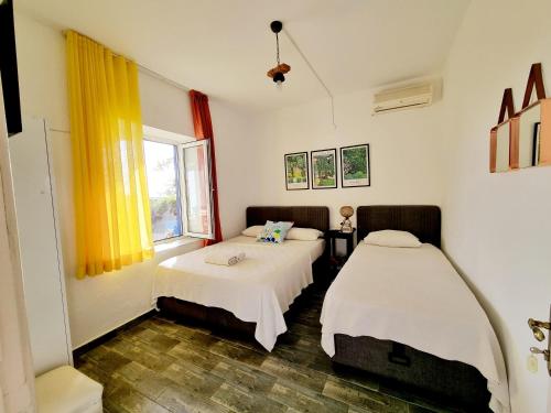 Habitación con 2 camas y ventana en Fethiye Motel BODRUM, en Bodrum City