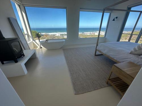 a bedroom with a bed and a view of the ocean at Atlantic Corner in Yzerfontein