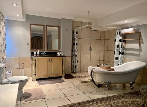 y baño con bañera, aseo y lavamanos. en Silken Trap Guest House NO LOADSHEDDING, en Johannesburgo