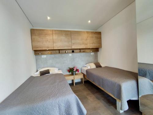 a bedroom with two beds and a cabinet at Luxury Mobile Home Kasthouse Oleander in Mali Lošinj