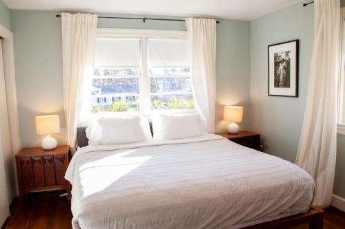 una camera da letto con un grande letto bianco e una finestra di Beautiful Ranch Style Home - Minutes from Downtown CVille! a Charlottesville