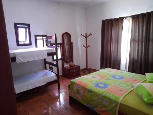 a bedroom with a bed and a bunk bed with a mirror at Hospedagem Tia Marli in Pomerode