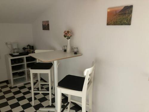 a kitchen with a table and two stools at Große schöne Mansardenwohnung mit 2 Balkonen in Lofer