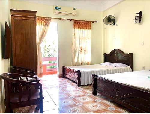 a bedroom with two beds and a large window at HaiAu Hotel in Quất Lâm