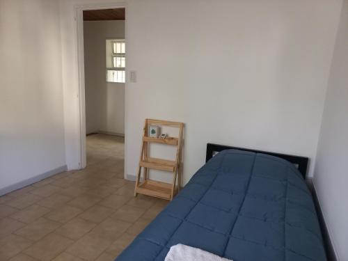 a bedroom with a blue bed and a ladder at Casa Luz in Neuquén