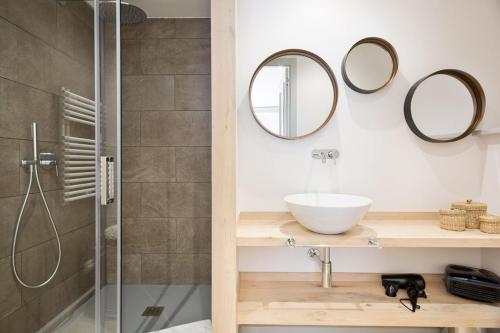 a bathroom with a shower and a sink and mirrors at Luderna - Apartamento con terraza Bonaigua B1 Joanchiquet in Baqueira-Beret