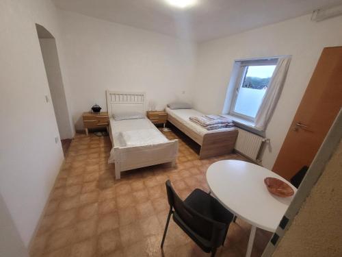 a room with a bed and a table and a window at Monteurzimmer/Ferienwohnung/Pension in Siegen